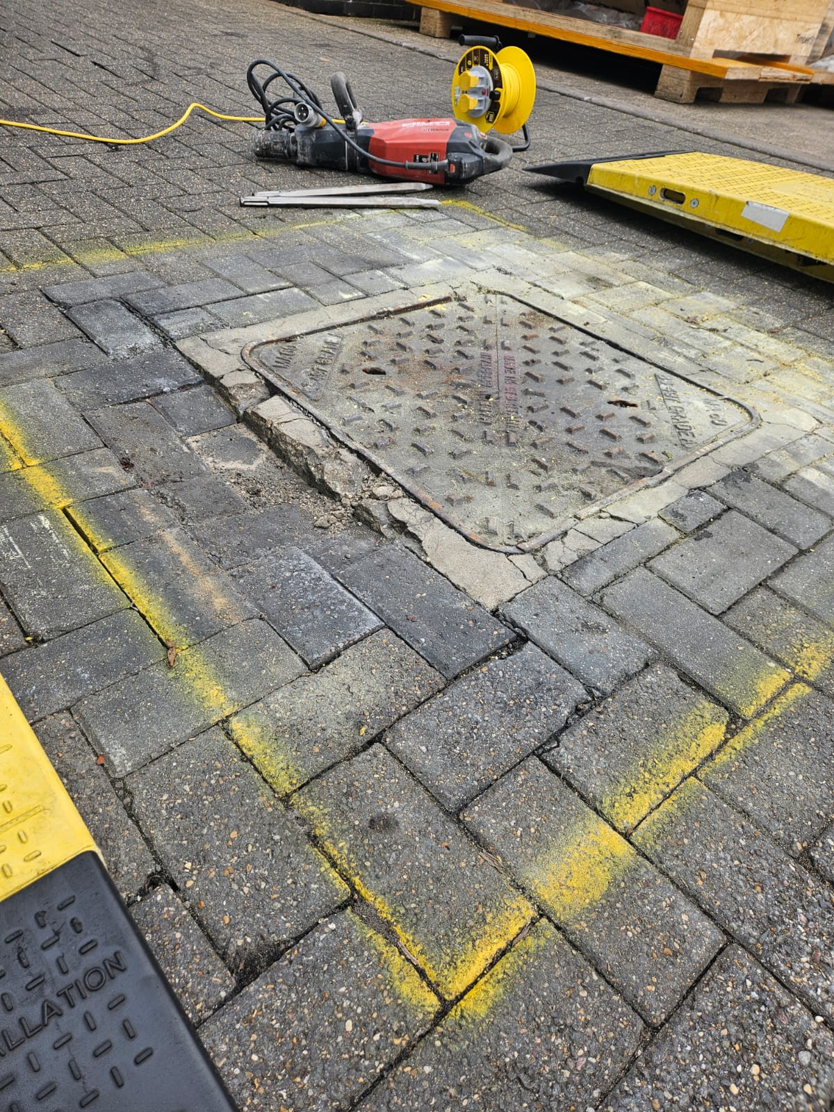 Defective manhole surround and uneven block paving before repair in Nottingham